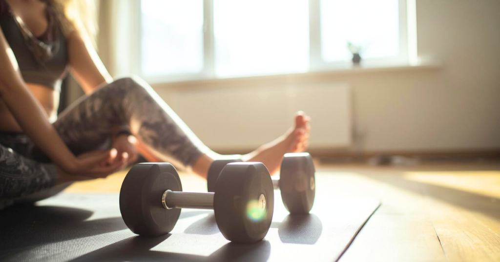 Home exercise setup with yoga mat and dumbbells for gentle movement.